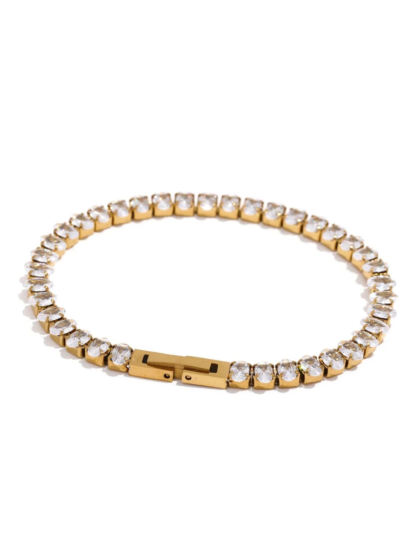 Gold rhinestone bracelet with clear stones on a white background